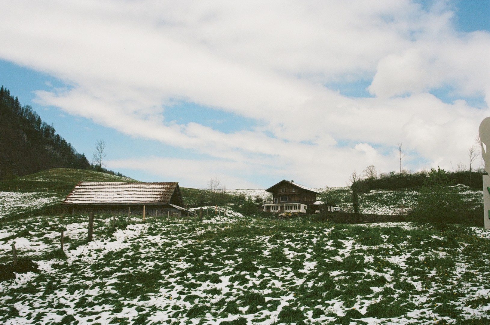A cute swiss cottage, in the mountains surrounded by snow. 