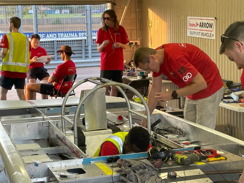 Image of me working on solar car in pit lane.