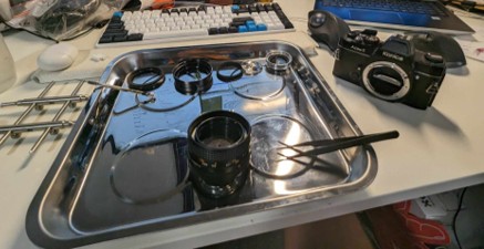 Cleaning and repairing the shutter and lens of a film camera.